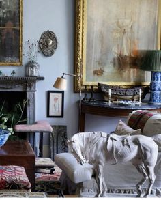 a living room filled with furniture and a fire place in front of a painting on the wall