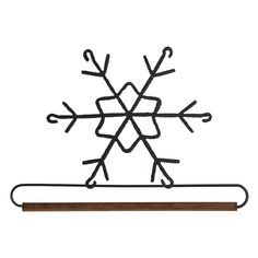 a metal snowflake on top of a wooden stick with black wire attached to it