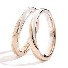 two gold wedding bands with the word love written on them