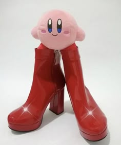 a pair of red boots with a pink face on them