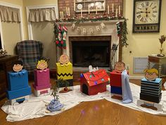 a group of cardboard figures sitting on top of a table next to a fire place