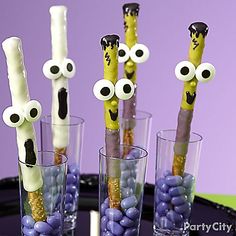 there are some toothpicks with googly eyes on them and candy in glasses