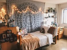 a bed room with a neatly made bed and a large tapestry hanging on the wall