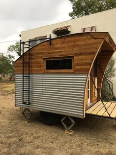 a tiny house on wheels with a ramp attached to the side and windows that are open