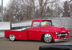 an old red truck parked in front of a building