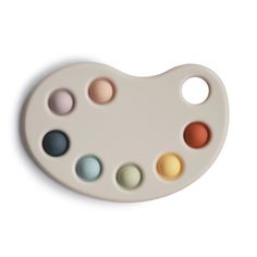 a white paint palette with six different colors on the bottom and one in the middle