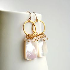 A luminous rectangle Mother of Pearl bead takes center stage in this earring. Clear quartz earrings sway from a golden circle.                                                         + Mother of Pearl. Clear Quartz. 14K Gold Plate Circle. 14K Gold Fill Ear Wire.                                                                                                                                   + Length: 1.75 inches. + Earrings are ready to ship. + Your jewelry will come in a jewelry box, tied with a Golden Circle, Mother Of Pearl Earrings, Women's Jewelry And Accessories, Quartz Earrings, Center Stage, Ear Wire, Clear Quartz, Pearl Beads, Mother Of Pearl