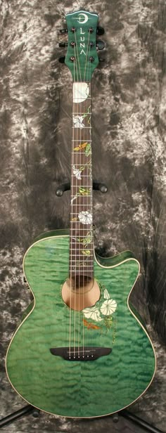 a green guitar sitting on top of a stand