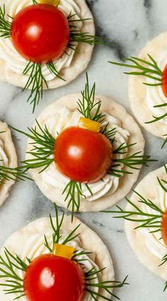 small appetizers with tomatoes and cream cheese are arranged on a marble countertop