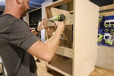 a man working on a cabinet in a shop