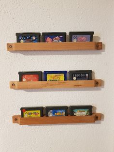 three wooden shelves holding video games on them