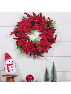 a christmas wreath with poinsettis and greenery is hung on the wall