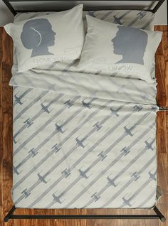 a bed with two pillows on top of it next to a pillow case and wooden floor