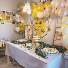 a table topped with cake and cupcakes next to balloons