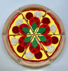 a pizza with several different toppings cut into four pieces and placed on a white surface