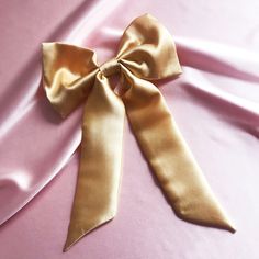 "Meet the super versatile Euphrasie hair bow, offering three in one hair ribbon styles. Detachable ribbon tails mean you can wear your bow on its own in our Lily hair bow style, with girlier bow tails or tie the bow tail onto a hair elastic (or even your scrunchie) for a simpler pony scarf style. If you only buy one hair accessory this year, make it our most multifunctional piece yet.  Adding the tails back to your hair bow is designed to be simple using a bobby pin to pull the silk back through Hair Bow Style, Ribbon Barrettes, Hair Bow Ribbon, Gold Hair Bow, Three In One, Bow Style, Gold Hair Accessories, Hair Elastic, Silk Accessories