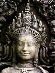 the head of a statue is surrounded by intricate carvings