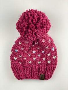 Mini Love Pom Hat (Child) - Warm, chunky, cozy knit hat - Color : Raspberry & Carousel - Material: Acrylic wool blend yarn, faux leather shop tag - Fit : Child: 19-21 inch head circumference - Care : Spot clean, lay flat to air dry - Ready to ship - If local to Des Moines area the shipping charge will be refunded and the hat will be hand delivered to the address on the order. - All sales are final.  Please contact shop with any issues.   Pattern credit Pine & Poppy Mini Love, Cozy Knit, Pom Pom Hat, Leather Shops, Des Moines, Knit Hat, Cozy Knits, Head Circumference, Air Dry