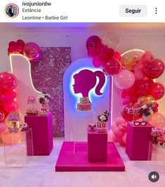 there is a display with pink and red balloons in the shape of a woman's head