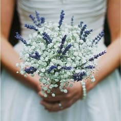 a bride holding a bouquet of baby's breath