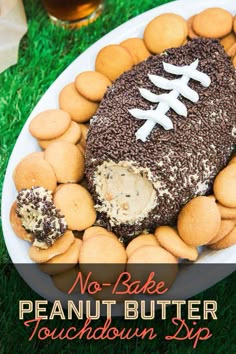 no bake peanut butter football cake on a platter surrounded by cookies and crackers