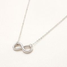 These beautiful necklaces will make the day of the most demanding sights! Carefully crafted with high-quality 925 Rhodium Plated Silver, bearing a beautiful design, these exclusive necklaces from our new collection will become a great present for your loved ones. The sterling silver infinity symbol pendant represents endless love and connection, making it a thoughtful gift or a meaningful addition to your own jewelry collection. Product Details: Metal: Sterling Silver Base Metal Purity: 925 Plat Sterling Silver Infinity Necklace In White Gold, Minimalist White Gold Infinity Necklace, Minimalist Infinity Clavicle Chain Necklace, Minimalist Infinity Necklace In White Gold, Classic Sterling Silver Infinity Necklace, Silver Infinity Jewelry, Silver Infinity Clavicle Chain Necklace, Silver Infinity Clavicle Chain Jewelry, Classic Silver Infinity Jewelry