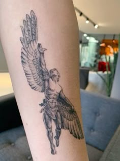 a woman's leg with a tattoo of an angel holding a bird on it