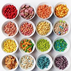 several bowls filled with different colored cereals