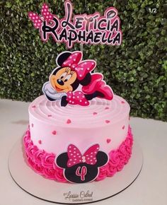 a pink cake with minnie mouse on top