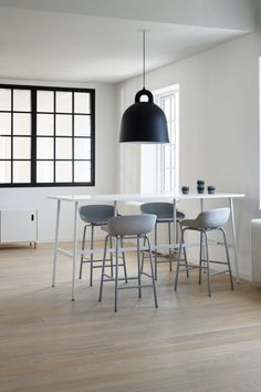 a dining table with four chairs and a black light hanging over it