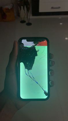 someone holding up their cell phone with a broken screen