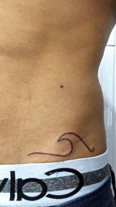 a man's stomach with a small wave tattoo on his left side ribcage