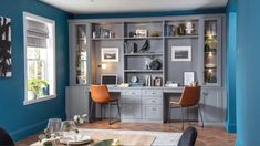 a living room with blue walls and wooden flooring, built in shelving units