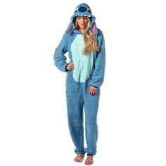 a woman in a blue animal onesuit is standing with her hands on her hips