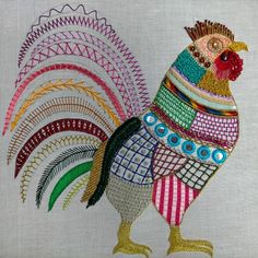 a colorful rooster is shown on a white linen material with multicolored stripes and circles