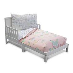 a toddler bed with pink and white sheets