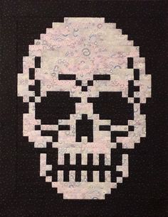 a black and white quilt with a large skull on it's face in the center