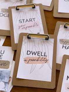 several clipboards with writing on them sitting on top of a wooden table next to each other