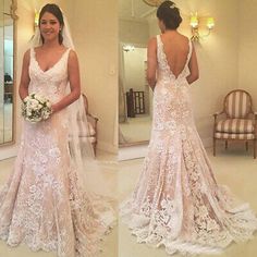 a woman in a wedding dress looking at herself in the mirror and holding a bouquet