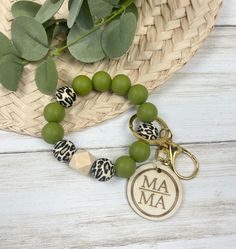 a green beaded bracelet with an animal print charm on it and a keychain