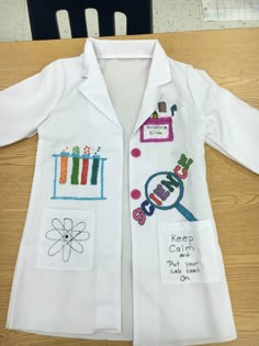 a child's lab coat with embroidered patches on it