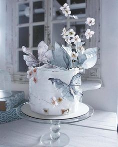 a white cake decorated with flowers and butterflies