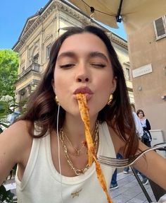 a woman eating food from a fork in front of her face