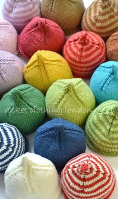 several knitted beanies are shown in different colors