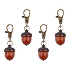 three wooden acorns hanging from hooks on a white background