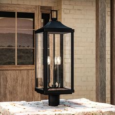 an old fashioned black lantern on a stone table