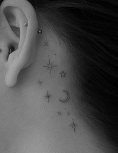 a woman's ear with stars and moon behind the ear