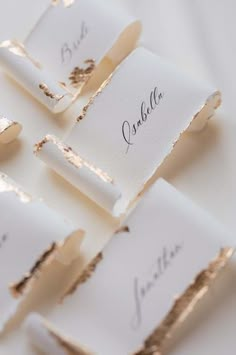 place cards with gold foil on them are arranged in the shape of rectangles