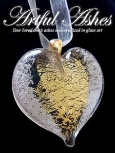 a heart shaped glass ornament with gold flecks on it's side