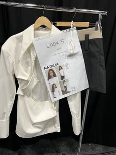 a white shirt is hanging on a clothes rack